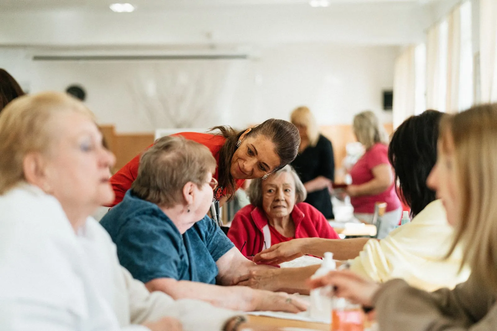 A caregiver chatting with residents at a table